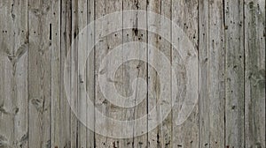 The texture of weathered wooden wall. Aged wooden plank fence of vertical flat board