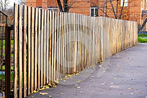 The texture of weathered wooden wall. Aged wooden plank fence of vertical flat boards