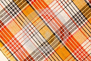 The texture of white checkered, orange, red, black cotton fabric