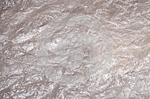 Texture of white crumpled cellophane surface transparent on sunlight. Concept of materials for packaging, product protection