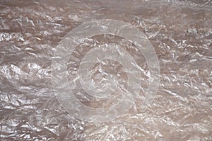 Texture of white crumpled cellophane surface transparent on sunlight. Concept of materials for packaging, product protection