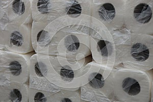 Texture of white rolls of toilet paper in cellophane packaging