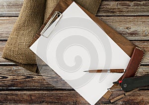 texture, a white sheet of writing paper on a wooden stand on a rustic table with a pen and pencils and a rough canvas