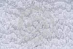 Texture of white snow on the wall outside in winter