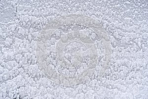 Texture of white snow on the wall outside in winter