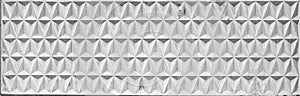 Texture of a wide decorative concrete wall panel with geometric pattern in the form of embossed triangles