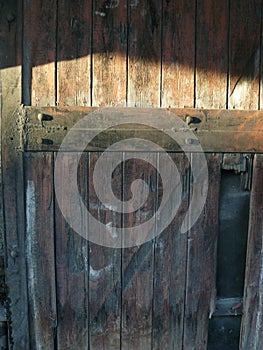 The texture of the wooden door of the boards and wrought iron