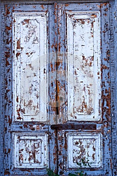 Texture of a wooden door. A wooden door with peeling paint. The old paint will climb from the old wooden door. Texture of wood