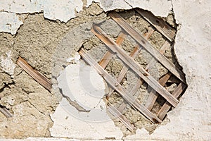 Texture of wooden planks and dry clay on the wall. The old plaster is crumbling.