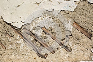 Texture of wooden planks and dry clay on the wall. The old plaster is crumbling.