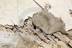 Texture of wooden planks and dry clay on the wall. The old plaster is crumbling.