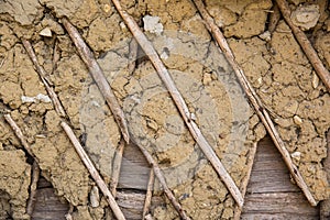 Texture of wooden planks and dry clay on the wall. The old plaster is crumbling.