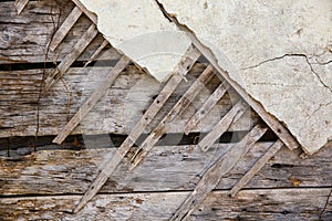 Texture of wooden planks and dry clay on the wall. The old plaster is crumbling.