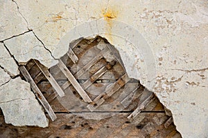 Texture of wooden planks and dry clay on the wall. The old plaster is crumbling.