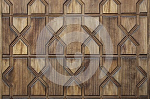 Texture of a wooden wall with carvings in the form of geometric