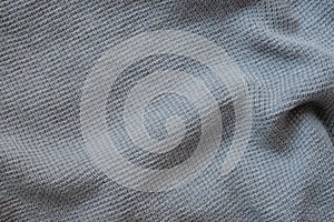 Texture of a woolen knitted gray blue sweater. Fabric background