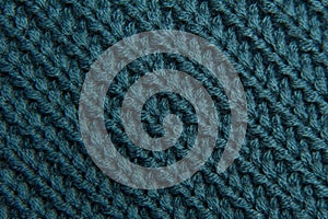 Texture of a woolen knitted green-blue sweater. Fabric turquoise background
