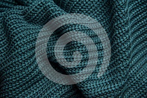 Texture of a woolen knitted green-blue sweater. Fabric turquoise background. Beautiful saturated color