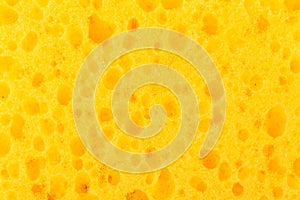 Texture yellow foam rubber, synthetic sponge with large pores, close-up background photo