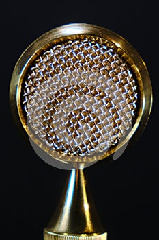 Texture of the yellow metal membrane of the microphone in the recording Studio. Wide membrane professional microphone golden color