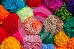 Textured background of assorted and multicolored wool pom poms