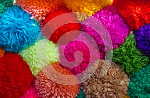 Textured background of assorted and multicolored wool pom poms