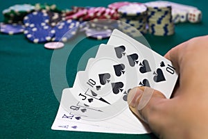 A close up image of stacked poker chips and a royal flush. A textured background.Copy paste place