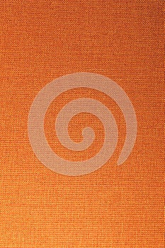 Textured background surface of textile upholstery furniture close-up. Orange color fabric structure