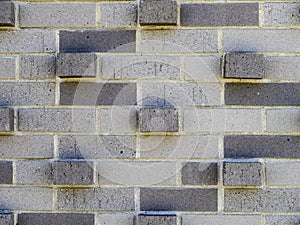 Textured brick wall of different colored grey bricks for abstract background