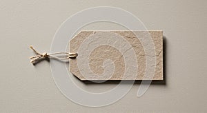 A textured, brown paper tag with a rectangular shape and angled corners lies on a
