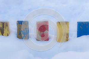 Textured Colorful Painted Blue, Red, Yellow Wooden Picket Fence Planks In Deep Snow, Colorful Rustic Style Background For Vintage