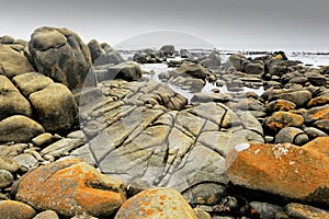 Textured and colourful granite rocks at the shore