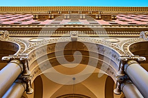 Textured details in ceiling and wall of building with tall pillars