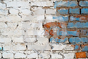 Textured grunge background. Brick wall with white and blue paint outdoors. Old, cracked horizontal brickwork