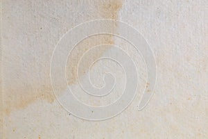 Textured paper with coffee stain on light surface