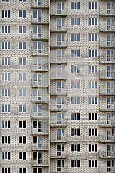 Textured pattern of a russian whitestone residential house building wall with many windows and balcony under constructio