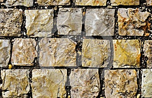 Textured rough and rustic cube beige granite stone pavement abstract of square shapes loosely set with joints