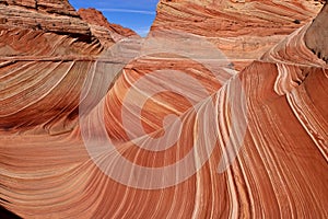 Textured sandstone red buttes under the blue sky.