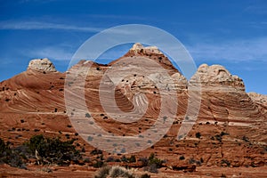 Textured sandstone red buttes under the blue sky.