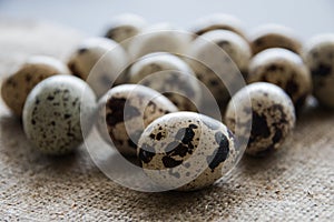 Textured spring background with small quail eggs on burlap background. Ecoproduct. Selective focus