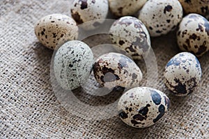Textured spring background with small quail eggs on burlap background. Ecoproduct. Selective focus