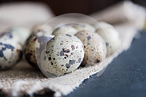 Textured spring background with small quail eggs on burlap background. Ecoproduct. Selective focus