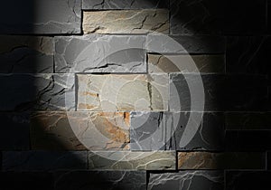Textured stone wall with dramatic spotlight illumination