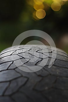 Textured surface of a car tire with geometric tread on a blurred background