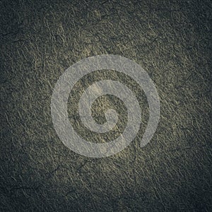 A textured surface featuring a dark, fibrous pattern. The material