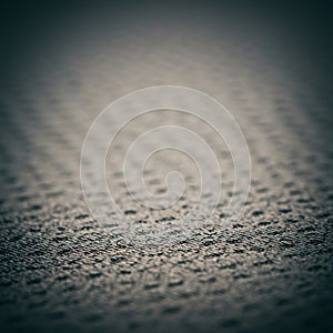 A textured surface featuring a uniform pattern of small, raised dots. The material