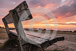 a close up of a wooden bench with a sunset in the background photo