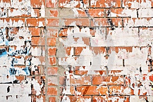 Textured torn poster paper against a rustic brick wall backdrop