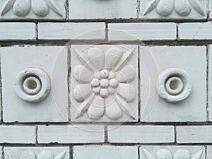 The textured wall is lined with decorative ceramic tiles with image of flowers