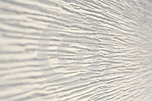 Textured white wall with horizontal lines, shot at an angle with blurring